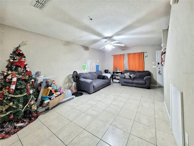 tiled living room featuring ceiling fan and a textured ceiling