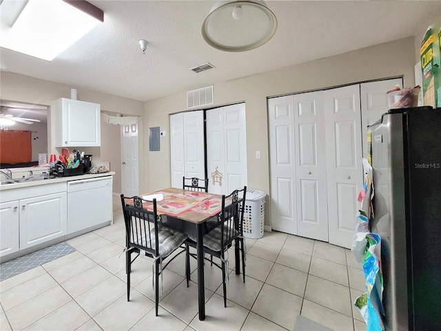 tiled dining room with ceiling fan, sink, electric panel, and a textured ceiling