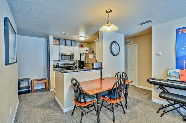 carpeted dining area featuring a textured ceiling