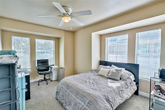 bedroom with ceiling fan, a textured ceiling, and light carpet