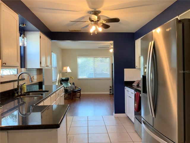 kitchen with tasteful backsplash, sink, white cabinets, stainless steel fridge with ice dispenser, and light tile patterned flooring