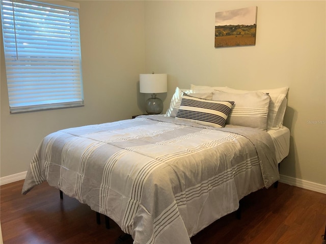 bedroom featuring multiple windows and dark wood-type flooring