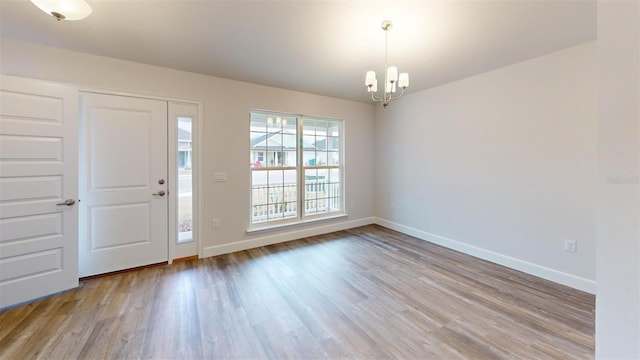 foyer with light hardwood / wood-style flooring and a chandelier