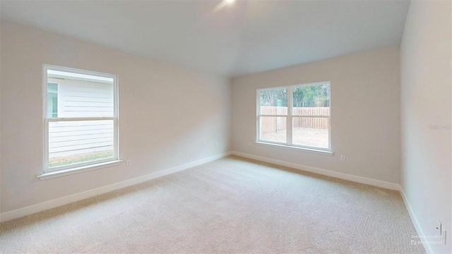 carpeted spare room featuring a wealth of natural light