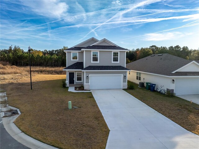 view of front of property featuring a front lawn, cooling unit, and a garage