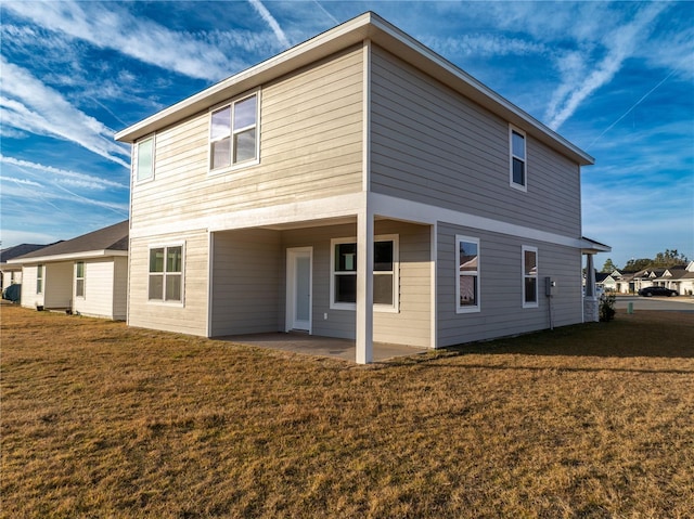 rear view of property featuring a lawn and a patio area