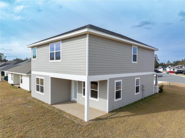 rear view of property featuring a patio area and a lawn