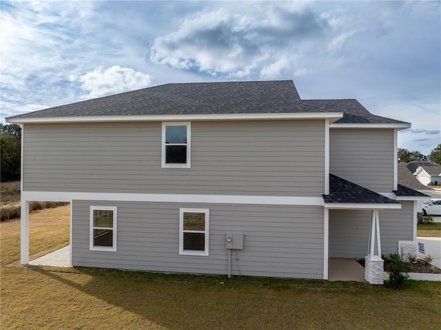 back of house featuring a patio area and a lawn