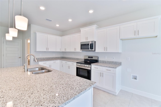 kitchen with appliances with stainless steel finishes, pendant lighting, white cabinets, and sink