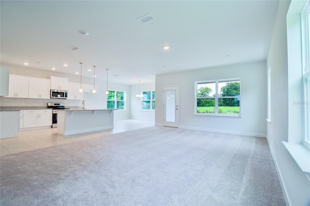 unfurnished living room with light colored carpet and sink