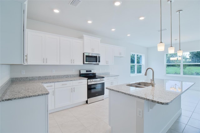 kitchen with sink, white cabinets, a center island with sink, and stainless steel appliances