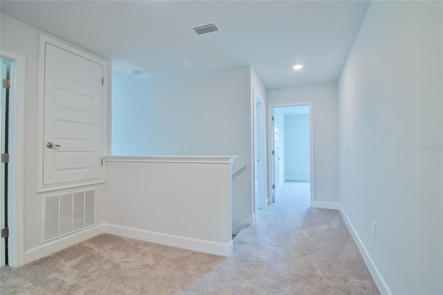 corridor featuring light colored carpet