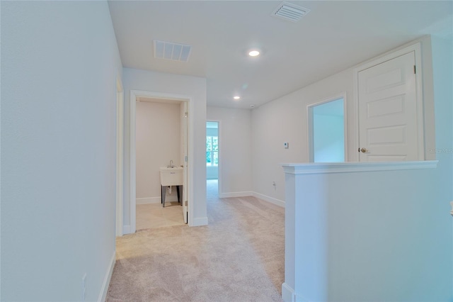 hallway featuring light colored carpet