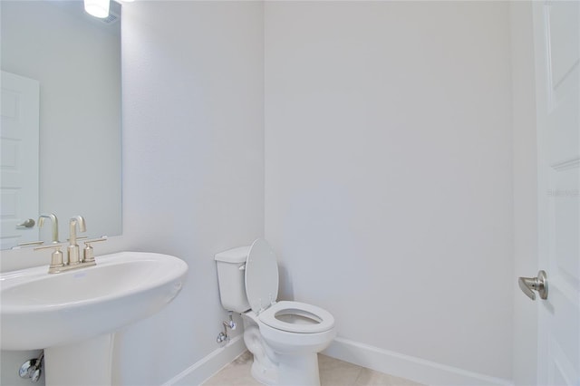 bathroom featuring toilet, tile patterned floors, and sink