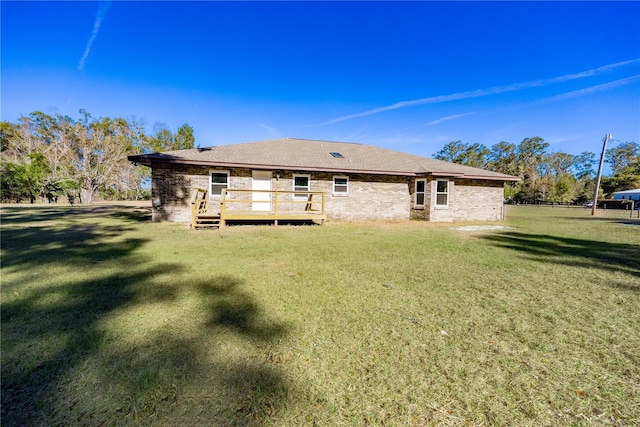 rear view of house featuring a deck and a lawn