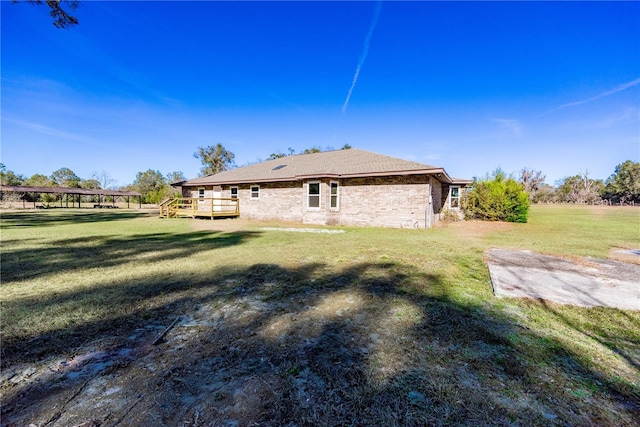 rear view of property with a lawn and a wooden deck