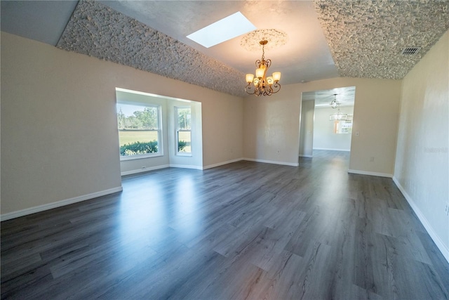 spare room with lofted ceiling, dark wood-type flooring, and a chandelier