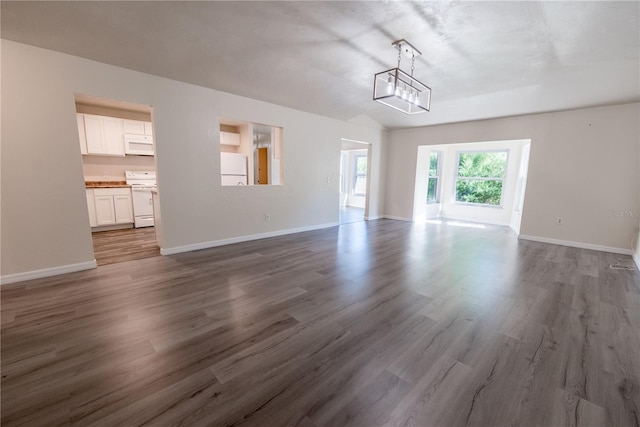 unfurnished living room with a chandelier, wood-type flooring, and vaulted ceiling