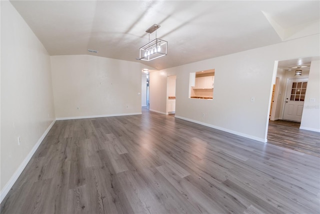 unfurnished living room with wood-type flooring and lofted ceiling