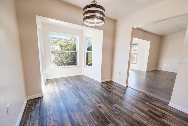 unfurnished dining area with a chandelier and dark hardwood / wood-style floors