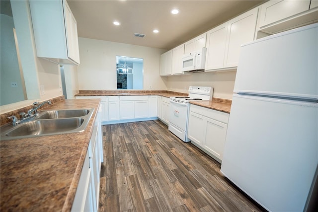 kitchen with kitchen peninsula, dark hardwood / wood-style flooring, white appliances, sink, and white cabinetry