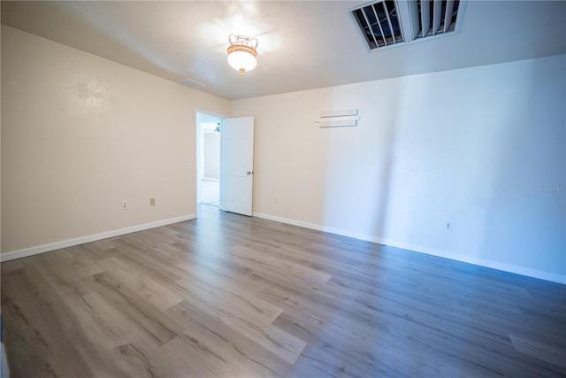 unfurnished room with hardwood / wood-style flooring