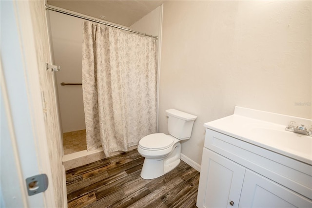 bathroom featuring hardwood / wood-style flooring, vanity, curtained shower, and toilet