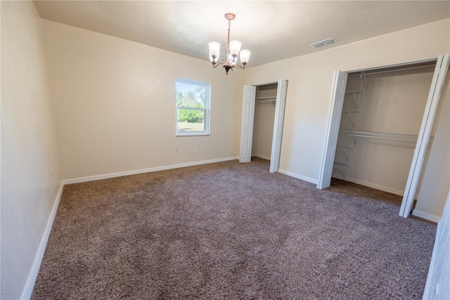 unfurnished bedroom with carpet floors and a notable chandelier