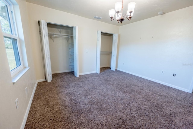 unfurnished bedroom with carpet, a notable chandelier, and a closet