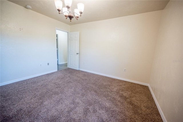 carpeted empty room with a chandelier