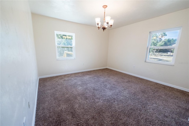 unfurnished room with carpet and a notable chandelier