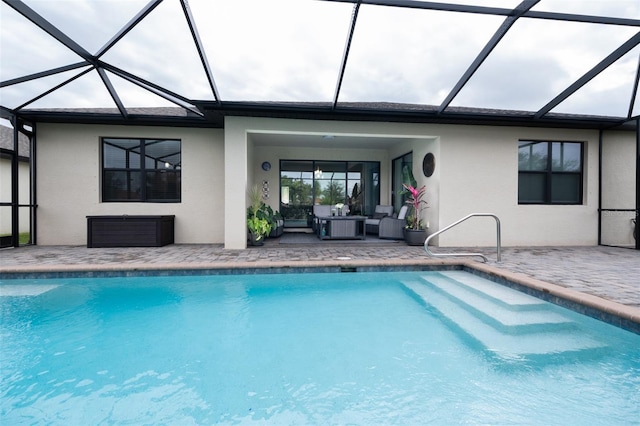 view of pool featuring an outdoor hangout area, a patio, and glass enclosure