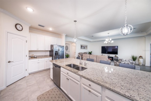 kitchen featuring white cabinets, stainless steel appliances, pendant lighting, light stone counters, and sink