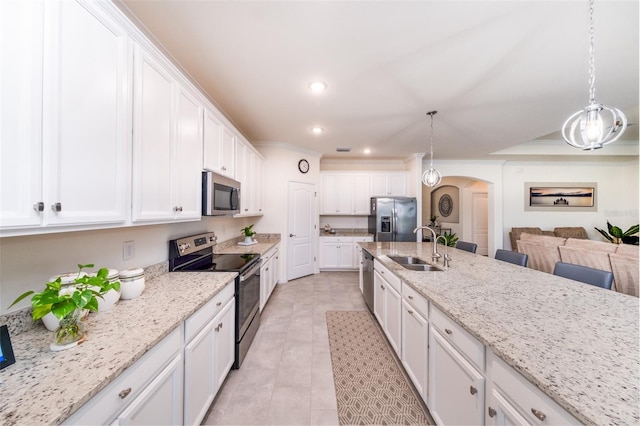 kitchen with decorative light fixtures, white cabinets, appliances with stainless steel finishes, and sink