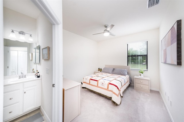 bedroom featuring ceiling fan, light colored carpet, and sink