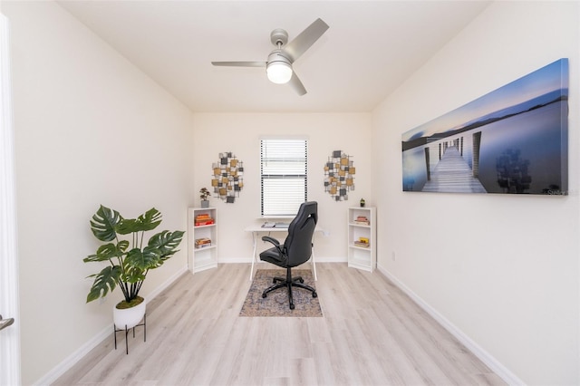 office with light wood-type flooring and ceiling fan