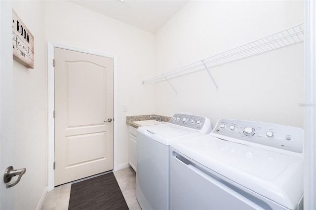 washroom featuring cabinets, light tile patterned flooring, and washer and clothes dryer