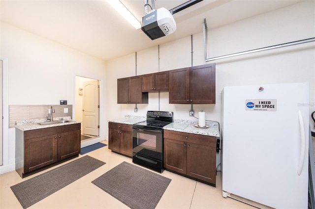 kitchen with white refrigerator, dark brown cabinets, black range with electric cooktop, and sink