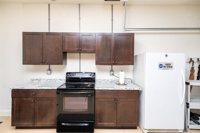 kitchen with white refrigerator, black electric range oven, light stone countertops, and dark brown cabinetry