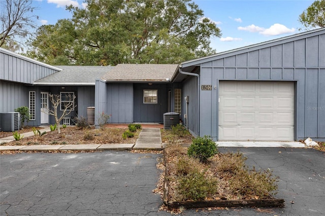 single story home with a garage and cooling unit