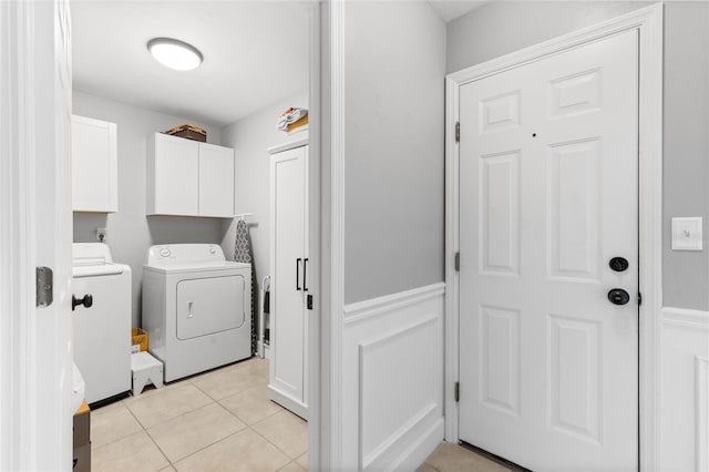 laundry area with cabinets, separate washer and dryer, and light tile patterned floors