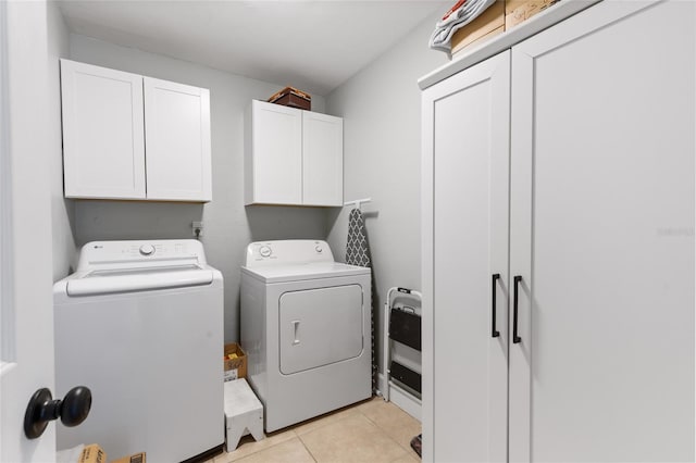 laundry room featuring heating unit, light tile patterned floors, cabinets, and washing machine and clothes dryer