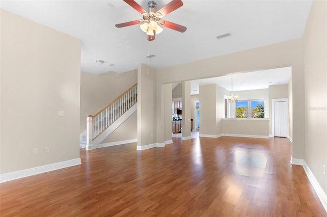 unfurnished living room with hardwood / wood-style flooring and ceiling fan with notable chandelier