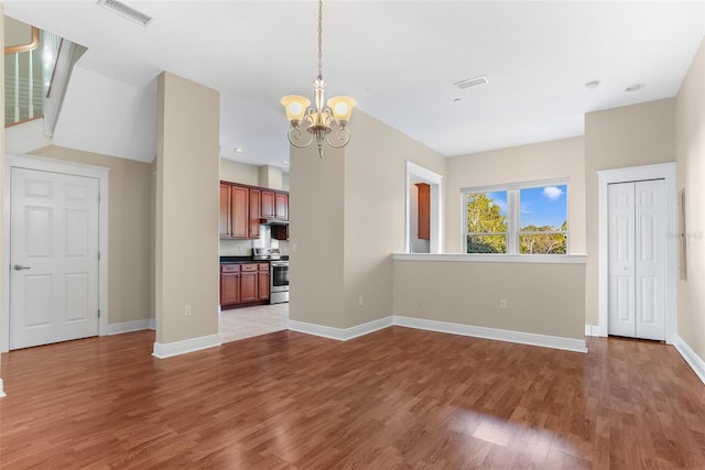 unfurnished living room with light hardwood / wood-style floors and an inviting chandelier