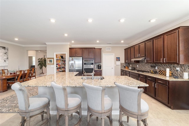 kitchen featuring a spacious island, appliances with stainless steel finishes, tasteful backsplash, ornamental molding, and light stone counters