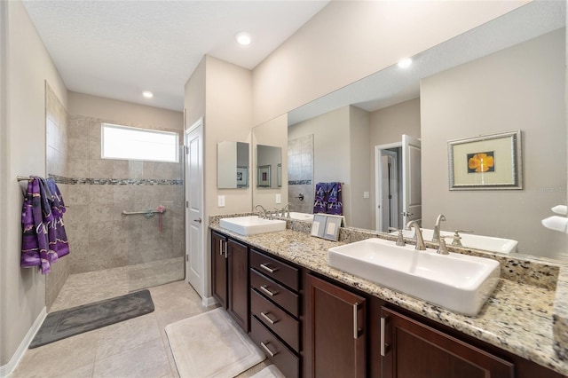 bathroom featuring tile patterned floors, vanity, and tiled shower