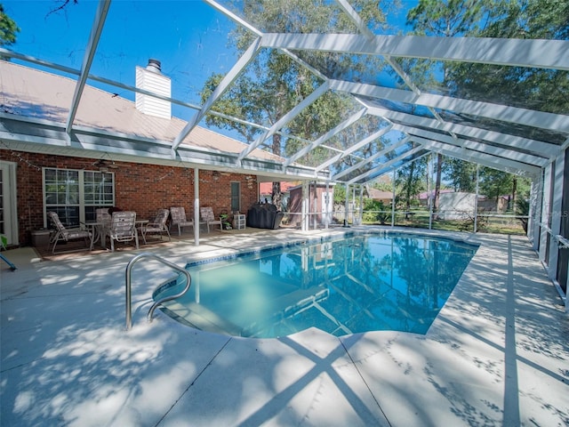 view of pool with a lanai, ceiling fan, and a patio