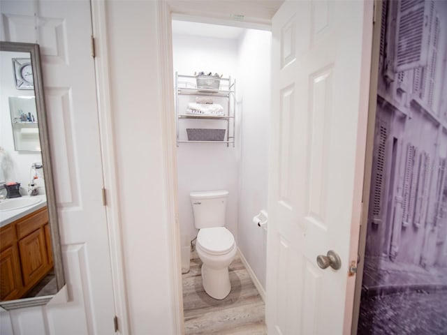 bathroom featuring vanity, wood-type flooring, and toilet