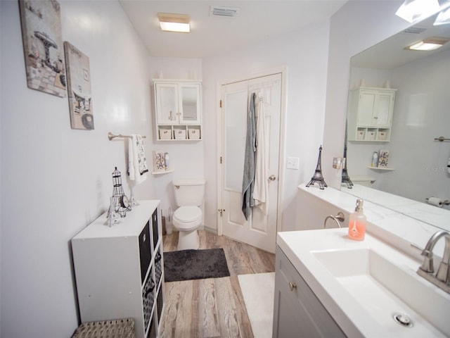 bathroom featuring hardwood / wood-style flooring, vanity, and toilet