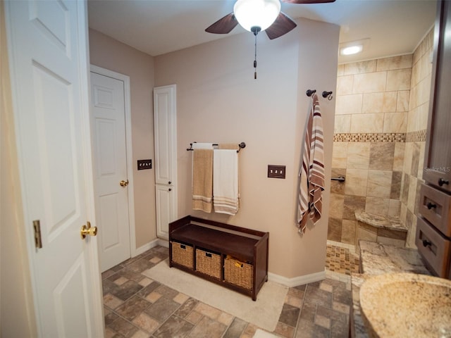 bathroom with a tile shower and ceiling fan